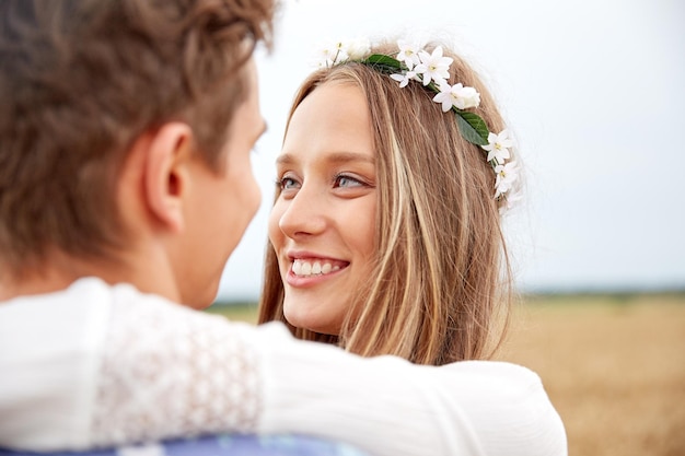 vacances d'été, amour, romance et concept de personnes - heureux souriant jeune couple hippie étreignant à l'extérieur