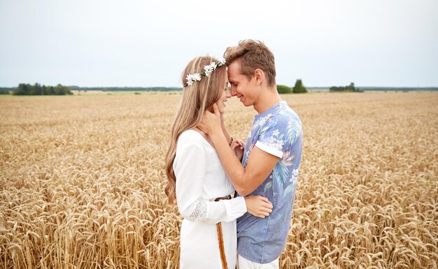 vacances d'été, amour, romance et concept de personnes - heureux souriant jeune couple hippie étreignant à l'extérieur