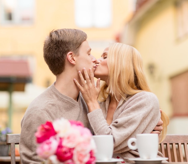 vacances d'été, amour, voyage, tourisme, relation et concept de rencontres - couple heureux romantique s'embrassant dans le café