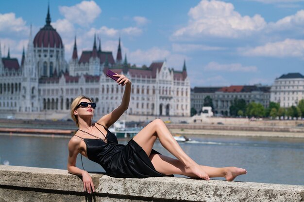 Vacances d'été sur budapest femme sexy en robe à la mode posant dans la rue près du parlement de budapest hig