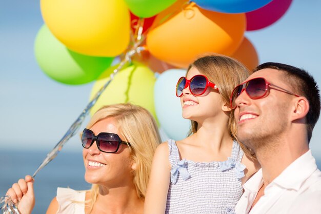 vacances d'été, célébration, concept d'enfants et de personnes - famille heureuse avec des ballons colorés à l'extérieur