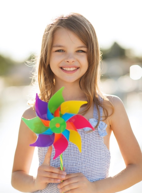 vacances d'été, célébration, concept de famille, d'enfants et de personnes - fille heureuse avec un jouet à moulinet coloré