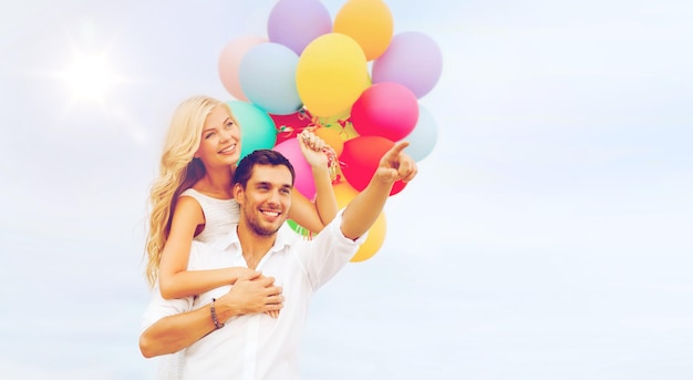 vacances d'été, célébration et concept de rencontres - couple avec des ballons colorés au bord de la mer