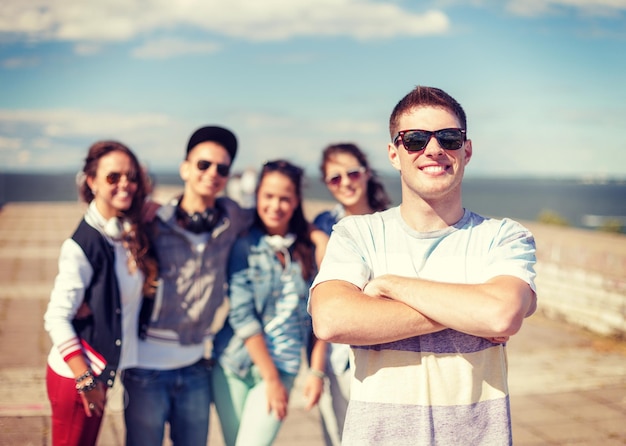 vacances d'été et concept adolescent - adolescent en lunettes de soleil traînant avec des amis à l'extérieur