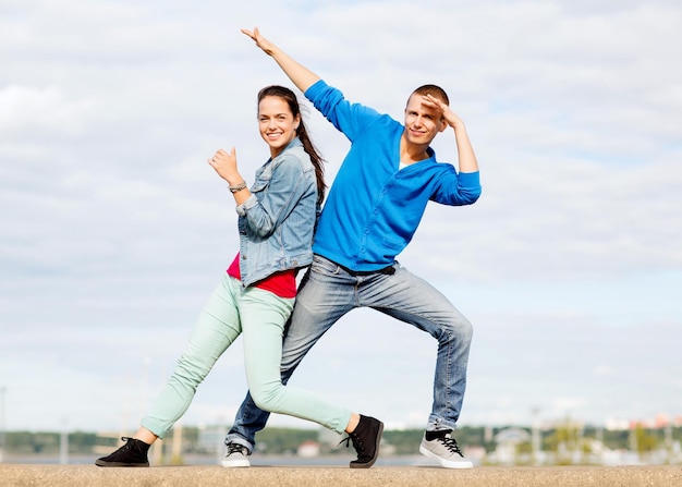 vacances d'été, concept d'adolescent et de danse - couple d'adolescents dansant à l'extérieur