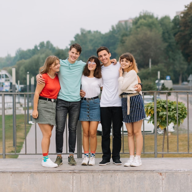 Vacances d&#39;été et concept adolescent - groupe d&#39;adolescents souriants qui traînent dehors.