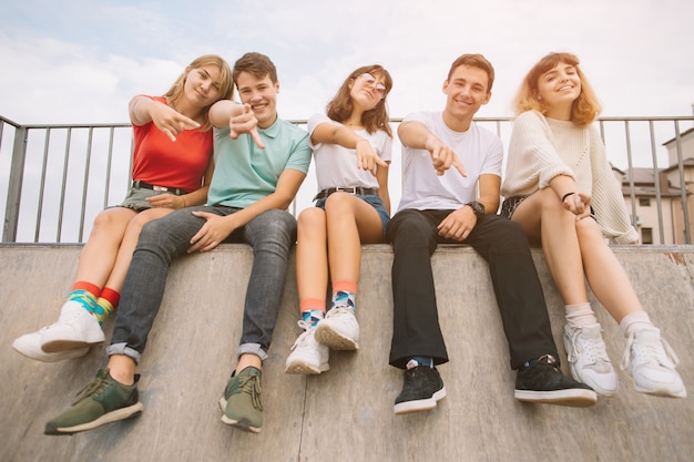 Vacances d&#39;été et concept adolescent - groupe d&#39;adolescents souriants qui traînent dehors.