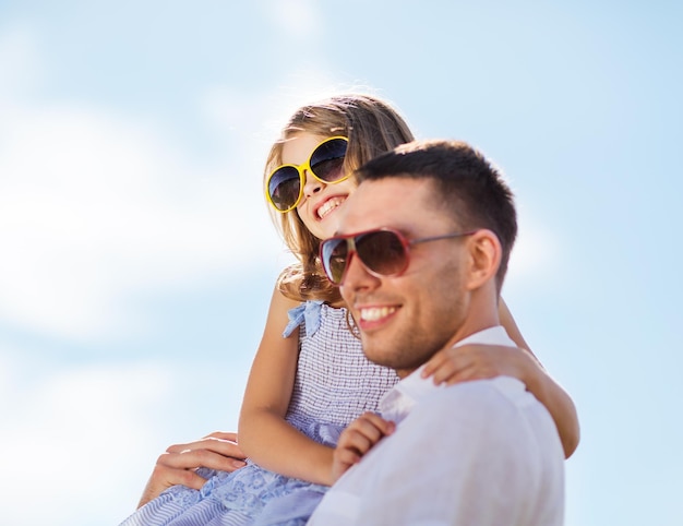 vacances d'été, concept d'enfants et de personnes - père et enfant heureux dans des lunettes de soleil sur le ciel bleu