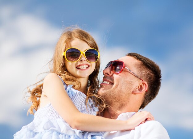 vacances d'été, concept d'enfants et de personnes - père et enfant heureux dans des lunettes de soleil sur le ciel bleu