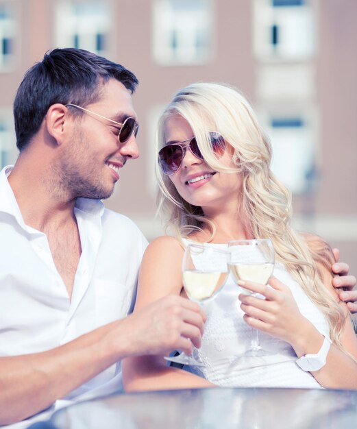 Photo vacances d'été et concept de rencontres - couple buvant du vin au café de la ville