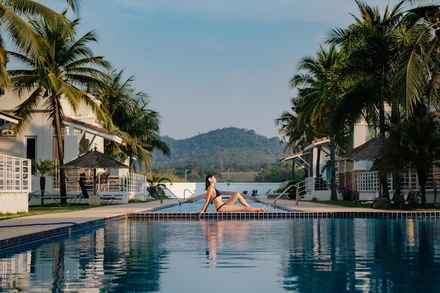 Vacances d'été dans un hôtel de luxe femme relaxante près d'une belle piscine Beauté et soins du corps Vue arrière sans visage