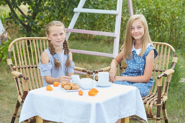 Vacances d'été Deux petites filles prenant le thé