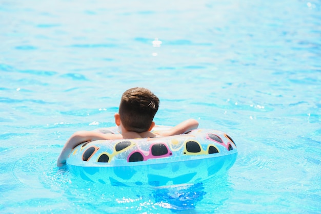 Vacances d'été pour enfants. Enfant nageant dans la piscine. Les enfants s'amusent au parc aquatique.