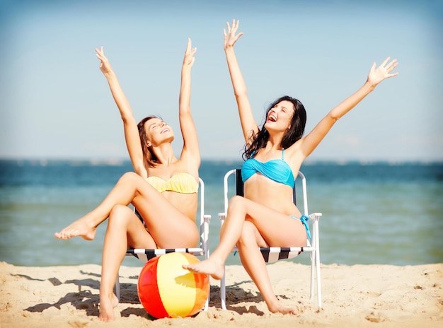 vacances d'été et vacances - filles bronzer sur les chaises de plage