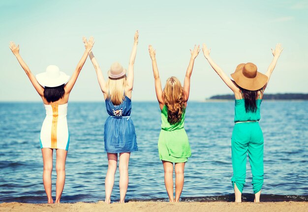 vacances d'été et vacances - filles avec les mains sur la plage