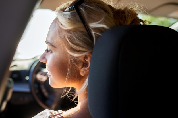 Photo vacances d'été, vacances, voyage, voyage sur la route et concept de personnes - adolescente heureuse ou jeune femme en voiture