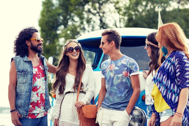 vacances d'été, voyage sur la route, vacances, voyage et concept de personnes - jeunes amis hippies souriants sur une mini-fourgonnette