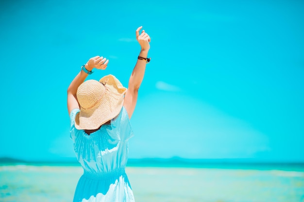 Vacances d'été voyage de vacances et concept de personnes jeune femme au chapeau de soleil sur la plage au-dessus de la mer et de l'espace de fond de ciel bleu