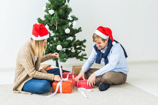 Vacances, famille et concept festif - Couple avec cadeaux de Noël à la maison.