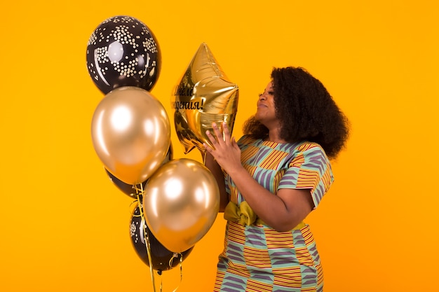 Vacances, fête d'anniversaire et concept amusant - Portrait de jeune femme souriante afro-américaine