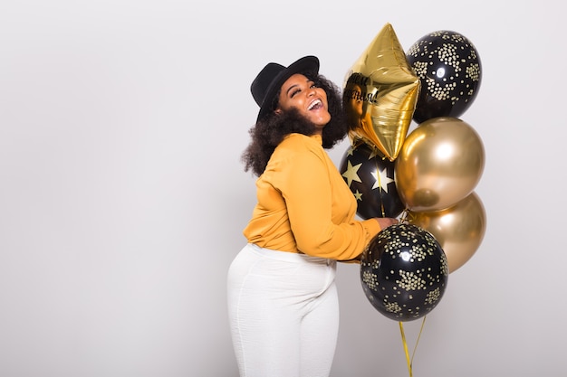 Vacances, fête et concept amusant - Portrait de jeune femme souriante afro-américaine à la recherche