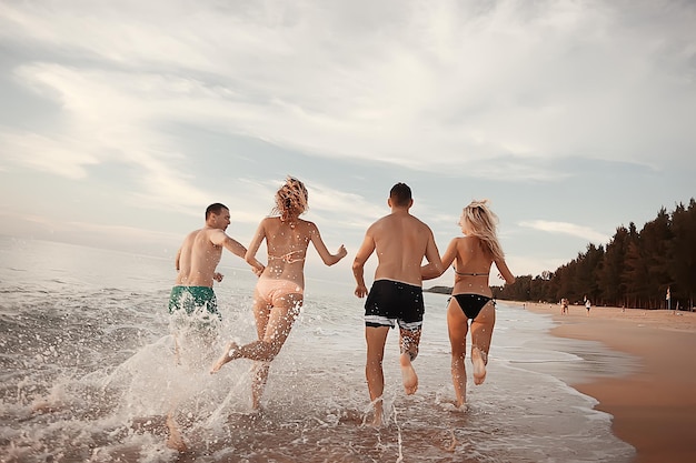 vacances, les gens courent sur la plage / vacances d'été, vacances en mer, les gens heureux se reposent