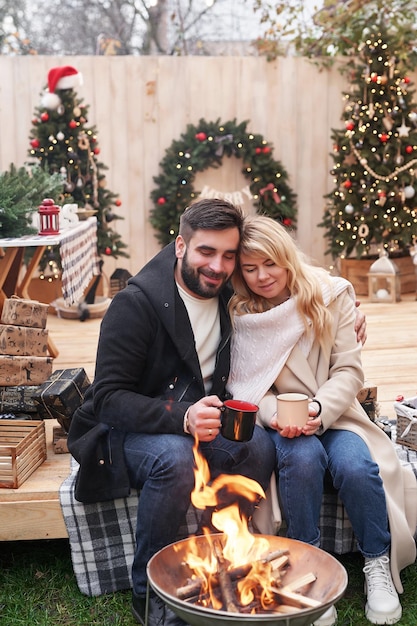 Vacances d'hiver et célébrations Couple de Noël amoureux près de l'arbre de Noël à l'extérieur