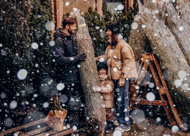 Vacances d'hiver et concept de personnes famille heureuse avec petite fille choisissant l'arbre de Noël à la foire aux arbres de Noël Bonne préparation pour la célébration des vacances du Nouvel An