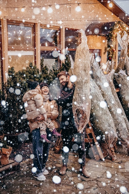 Vacances d'hiver et concept de personnes famille heureuse avec petite fille choisissant l'arbre de Noël à la foire aux arbres de Noël Bonne préparation pour la célébration des vacances du Nouvel An