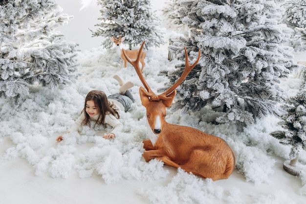 Vacances d'hiver et concept de personnes heureuse petite fille près de l'arbre de noël à la maison