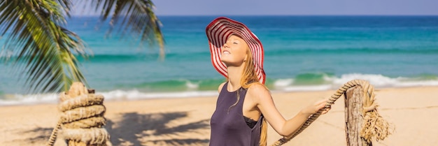 Vacances sur l'île tropicale femme au chapeau profitant de la vue sur la mer depuis le pont en bois bannière format long