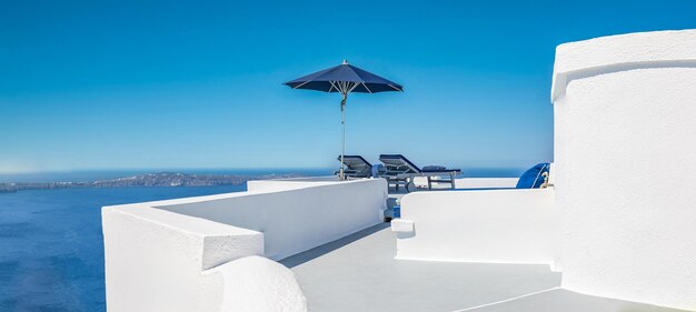 Vacances méditerranéennes, style de vie d'été avec chaises longues, parasol sur la terrasse blanche Santorini Grèce