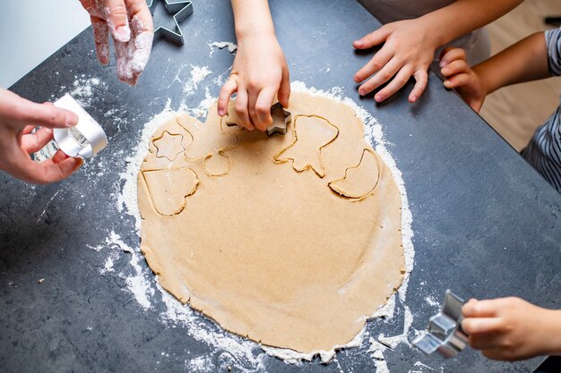 Vacances de Noël et du nouvel an, maman et enfants préparent des biscuits en pain d'épice