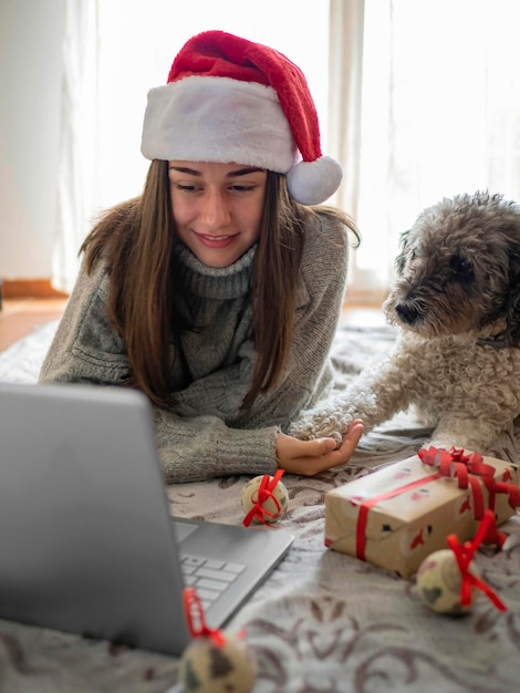 Photo vacances de noël en ligne heureuse femme ayant un appel vidéo avec sa famille ou ses amis