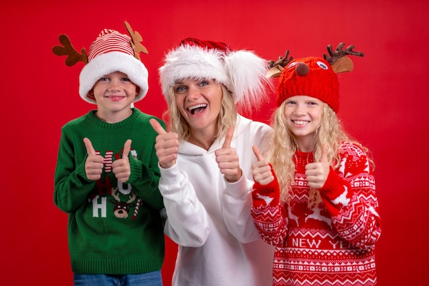 Vacances de Noël portrait famille heureuse de trois en santa hats mère et enfants debout et souriant