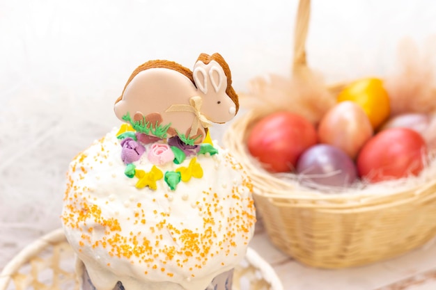 Vacances de Pâques Oeufs colorés dans un panier Lapin de pain d'épice de Pâques sur le sandwich sur un fond en bois clair