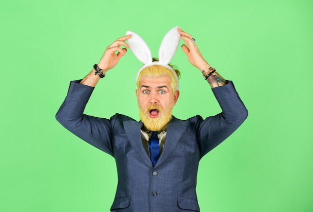 Photo vacances de printemps un homme d'affaires porte un accessoire de costume de lapin un homme barbu touche des oreilles de lapin sur la tête fête de pâques et amusement saison de printemps célébration de l'équinoxe de printemps le printemps est là