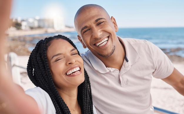 Vacances selfie couple heureux et noir à la plage lune de miel paix et détente au bord de l'océan à Porto Rico Mémoire sourire et portrait d'un homme et d'une femme excités avec une photo en vacances au bord de la mer