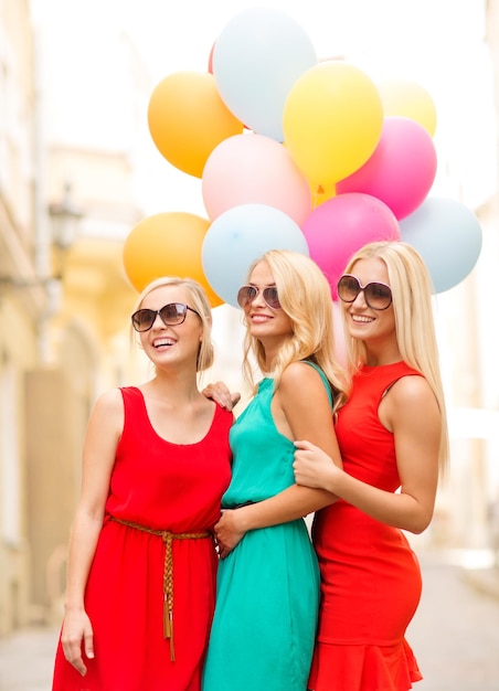 vacances et tourisme, amis, enterrement de vie de jeune fille, concept de filles blondes - trois belles femmes avec des ballons colorés dans la ville