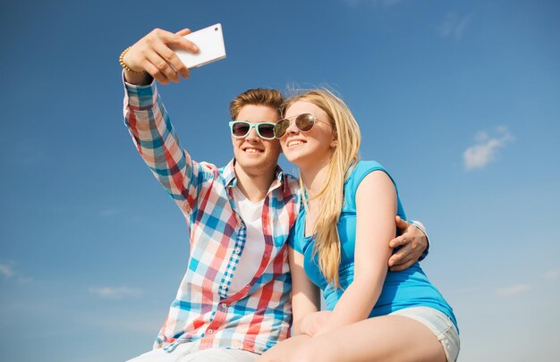 vacances, vacances, concept d'amour et d'amitié - couple souriant s'amusant à l'extérieur