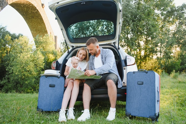 Vacances, Voyage - famille prête pour le voyage pour les vacances d'été. valises et trajet en voiture. Personnes avec carte en mains planifiant un voyage sur la route. concept de voyage. voyageur.