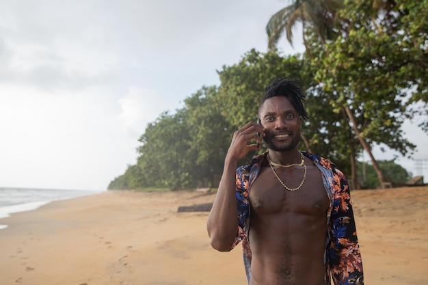 Un vacancier passe un coup de fil en marchant sur le sable de la plage