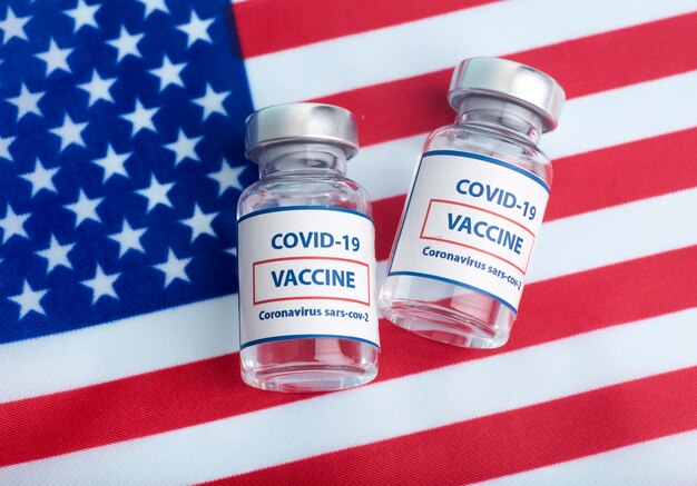 Vaccin américain contre le concept de coronavirus covid. Ampoules de vaccin dans le contexte du drapeau national. Concept de pharmacologie et médecine USA. photo de haute qualité