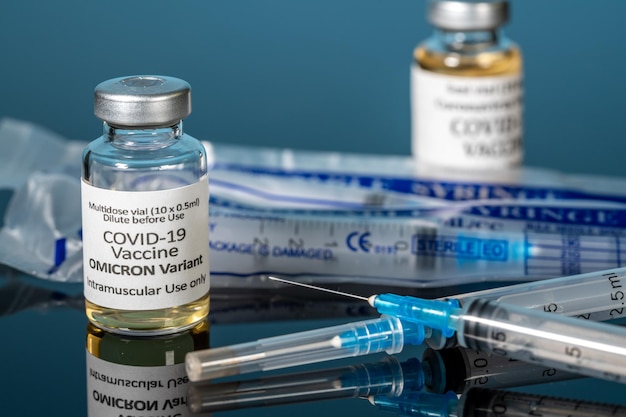 Vaccin contre le coronavirus Covid19 développé pour la variante Omicron avec aiguille de seringue hypodermique et nouvelles seringues en arrière-plan