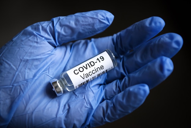 Vaccin contre le coronavirus COVID19 sur la paume de la main gantée