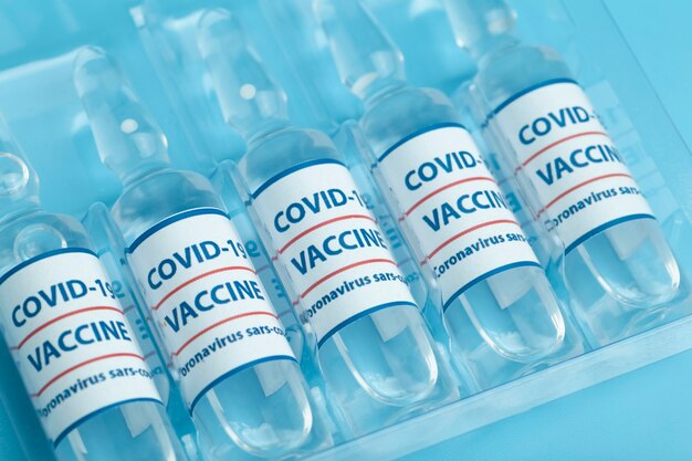 Vaccin contre COVID-19. Flacons médicaux en verre avec liquide. Ampoules avec vaccin contre le coronavirus sur une table en verre médical