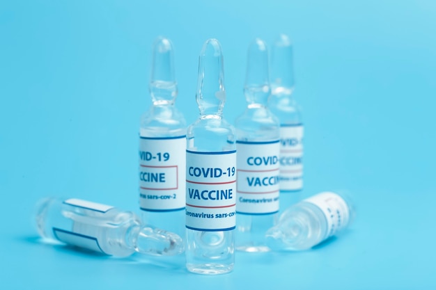 Vaccin contre COVID-19. Flacons médicaux en verre avec liquide. Ampoules avec vaccin contre le coronavirus sur une table en verre médical