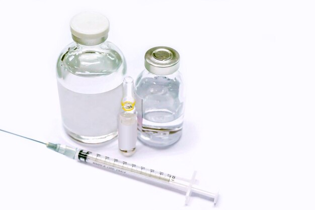 Vaccin en flacon flacon et ampoule de 3 ml de médicament et seringue en plastique sur fond blanc