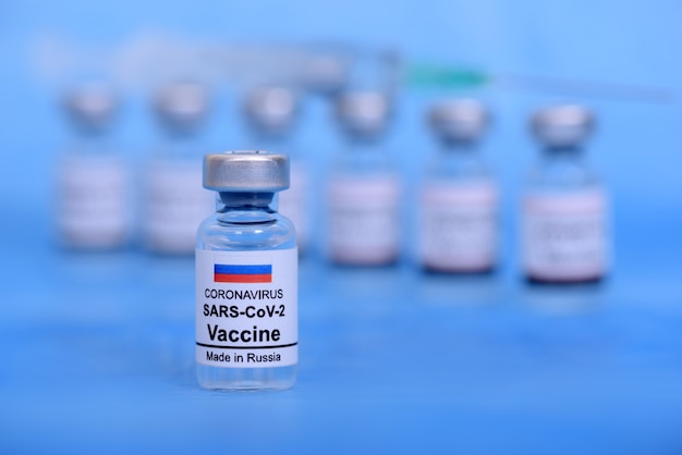 Vaccin russe et concept médical de soins de santé. Vaccins et seringue sur fond bleu pour la prévention, l'immunisation et le traitement de l'infection par le virus corona