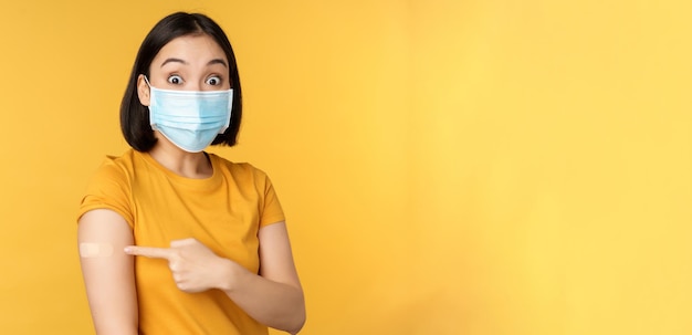 La vaccination contre le covid et le concept de santé a excité une femme asiatique dans un masque médical pointant du doigt un